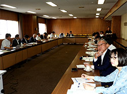 柴田氏（左列左端）の卓話で画面に表示されたデータを見る出席者